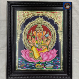 Orange Ganesha seated on pink lotus Tanjore painting with circular halo and black wooden frame